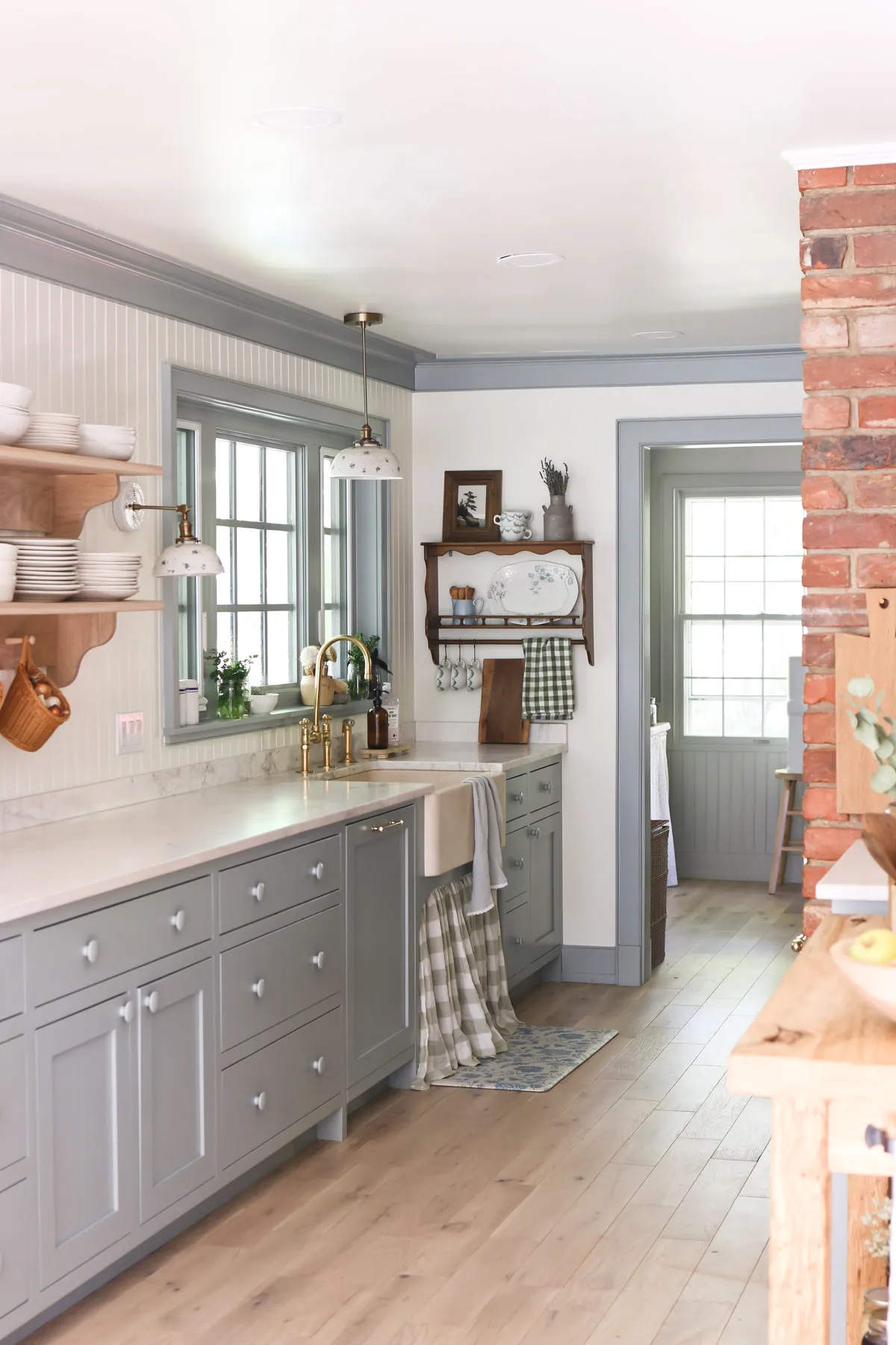 Gray inset kitchen cabinets with a farmhouse sink and open wood shelves in Cove, UT