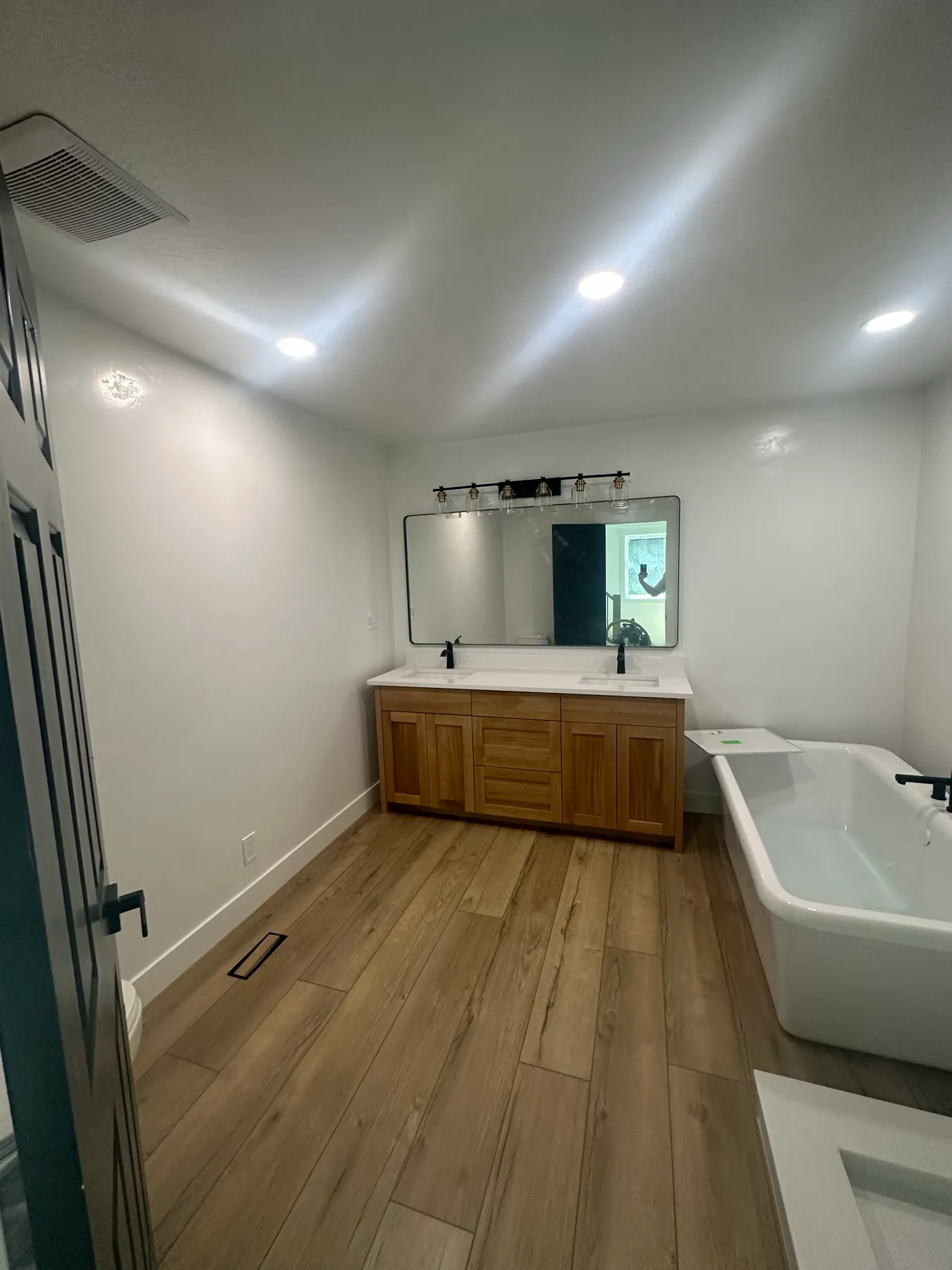 Remodeled bathroom with a double vanity and freestanding tub